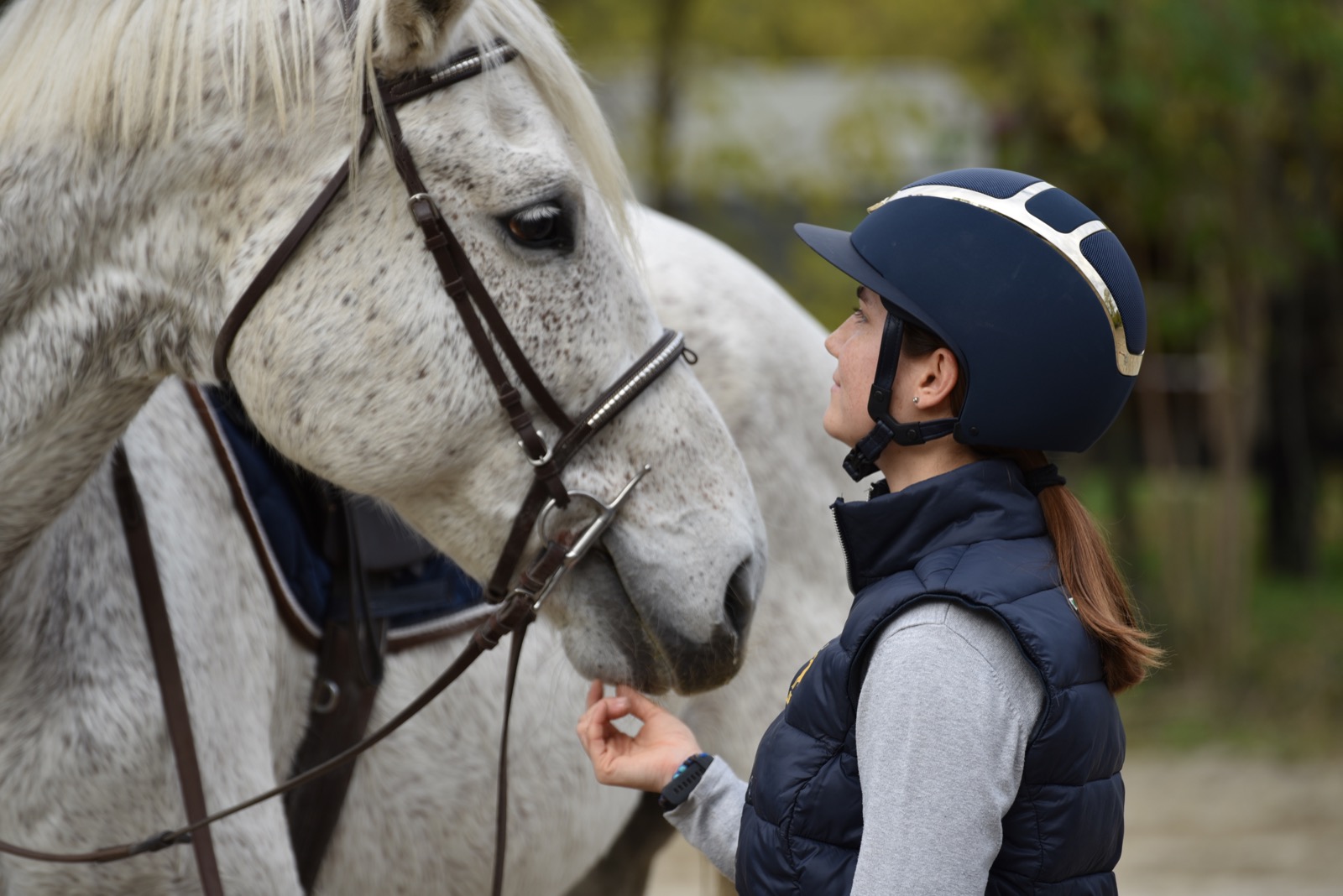 Un'allieva accarezza un cavallo grigio al Sant'Antonio Equestrian Center